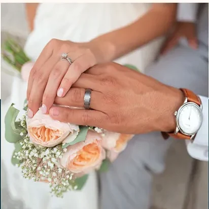 Two hands together, both wearing rings.