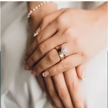 Hands resting, a ring on one finger.
