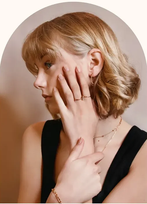 A person in three-quarter profile, hand raised to the cheek.